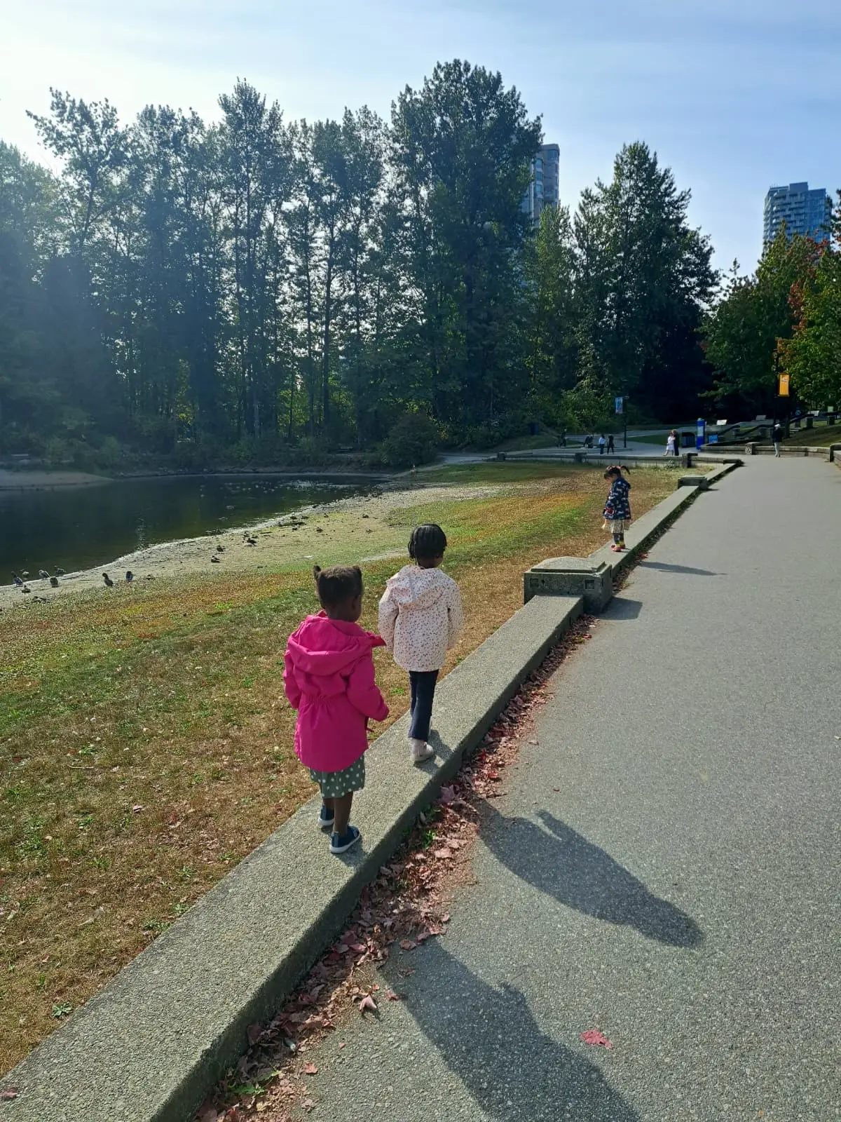 Children walking beside a lake in a Coquitlam park