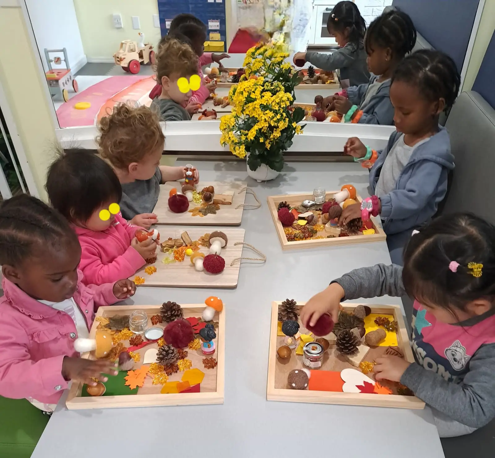 Children exploring autumn sensory materials at a table