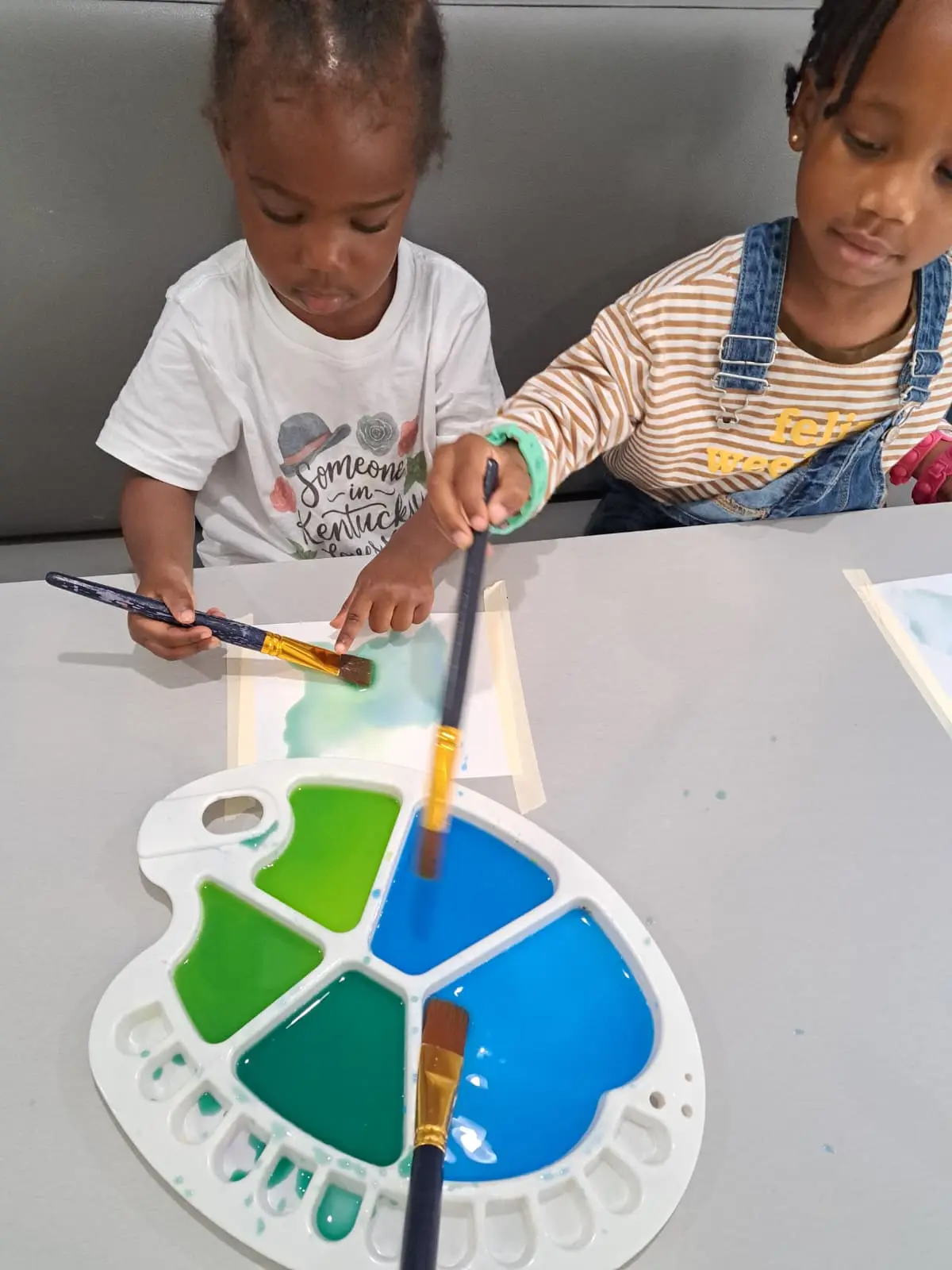 Children painting together at the daycare