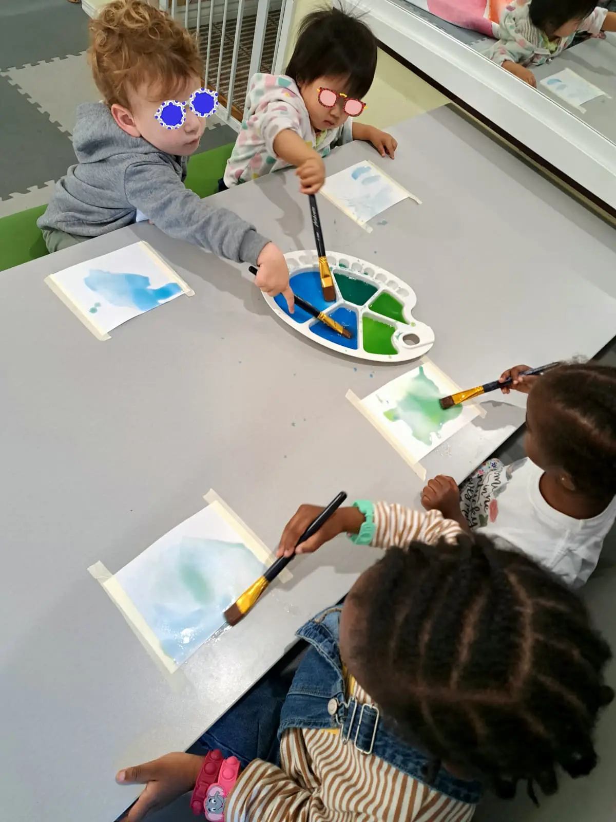 Children painting with watercolor at a table